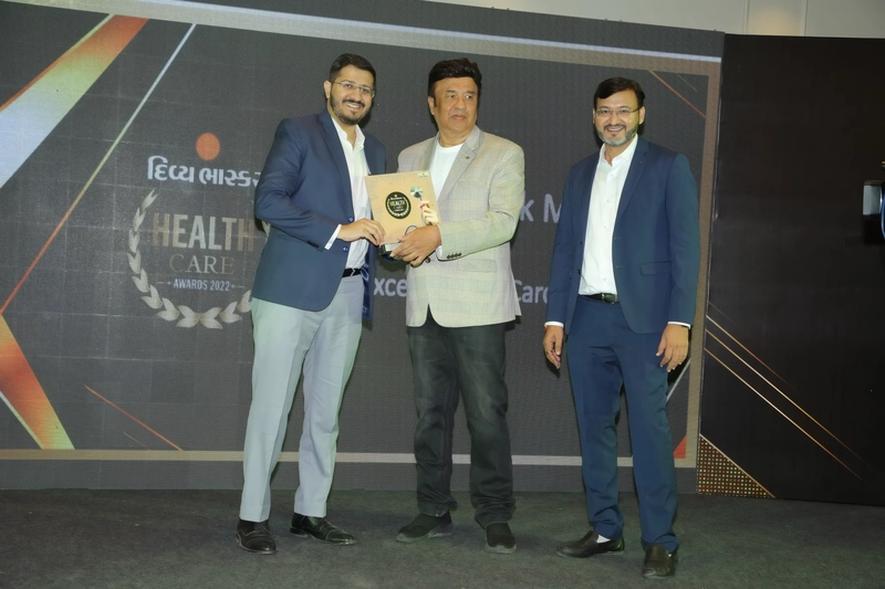 Dr. Priyank Mody receiving a Healthcare Excellence Award from Indian composer and singer Anu Malik